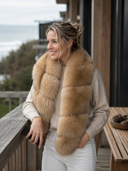 Woman wearing a golden brown blue fox fur scarf on a coastal terrace