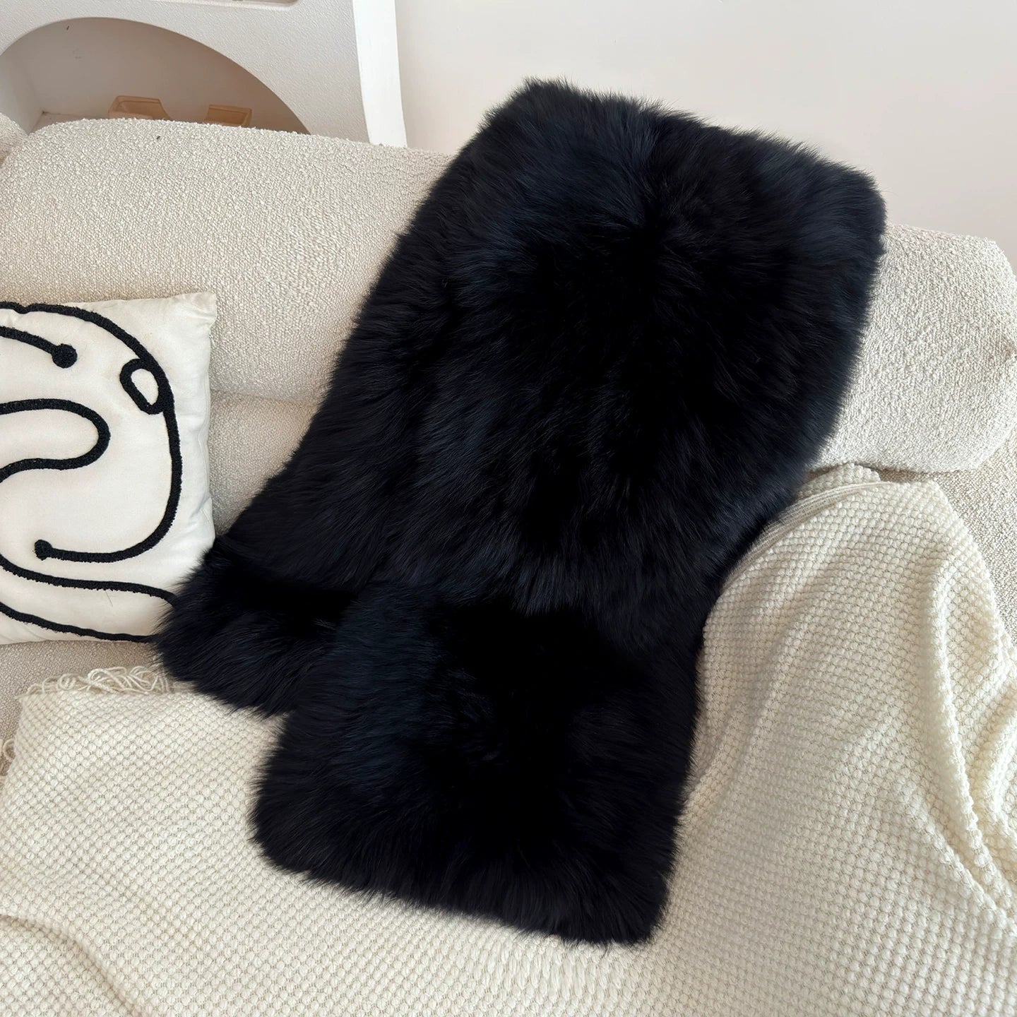 Natural Black genuine fox fur shawl arranged on a cream chair