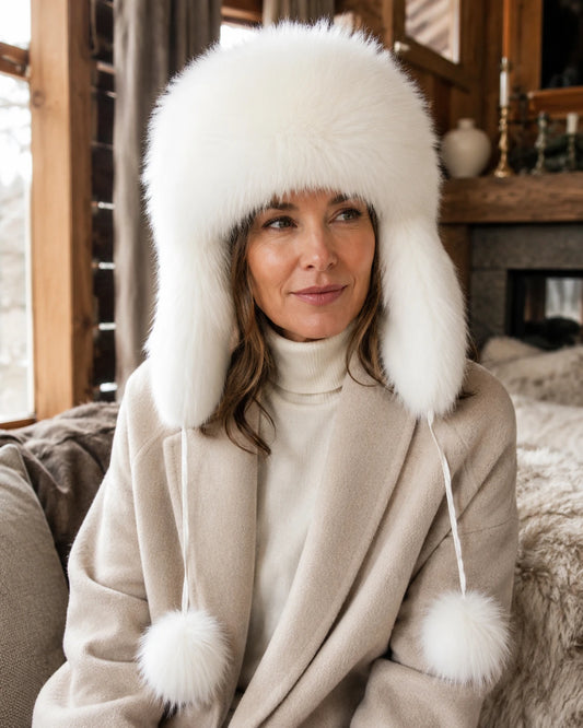 Soft ivory genuine natural-fur ushanka hat worn in a warm wood interior