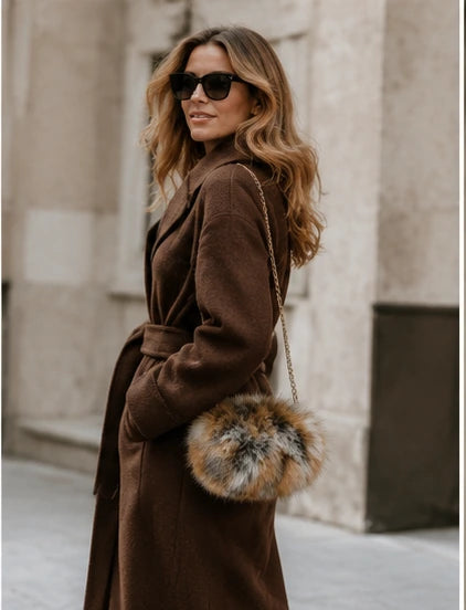 Red fox fur chain muff bag carried with a brown winter coat
