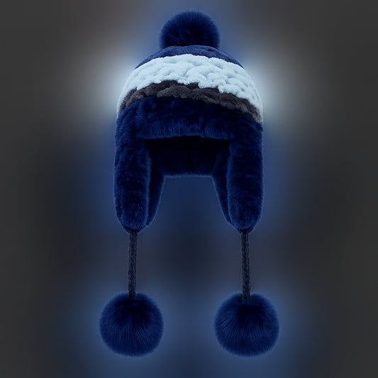 Front view of a blue Rex rabbit fur earflap hat with striped crown and fox fur pom-poms