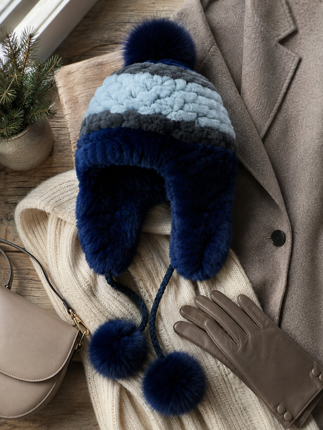 Blue Rex rabbit fur earflap hat styled with a winter coat, knitwear, gloves, and handbag