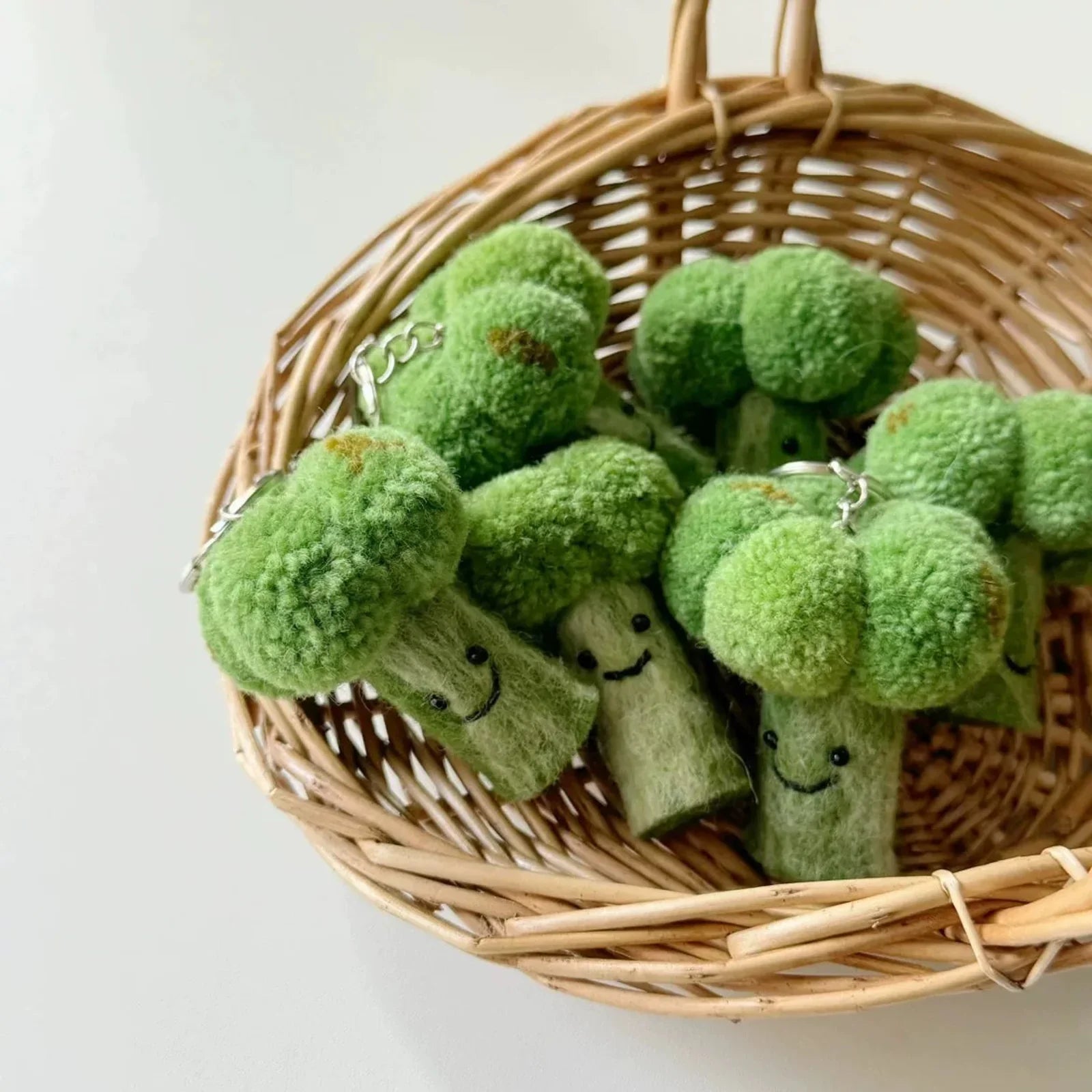 Wool felt broccoli charms displayed in a woven basket