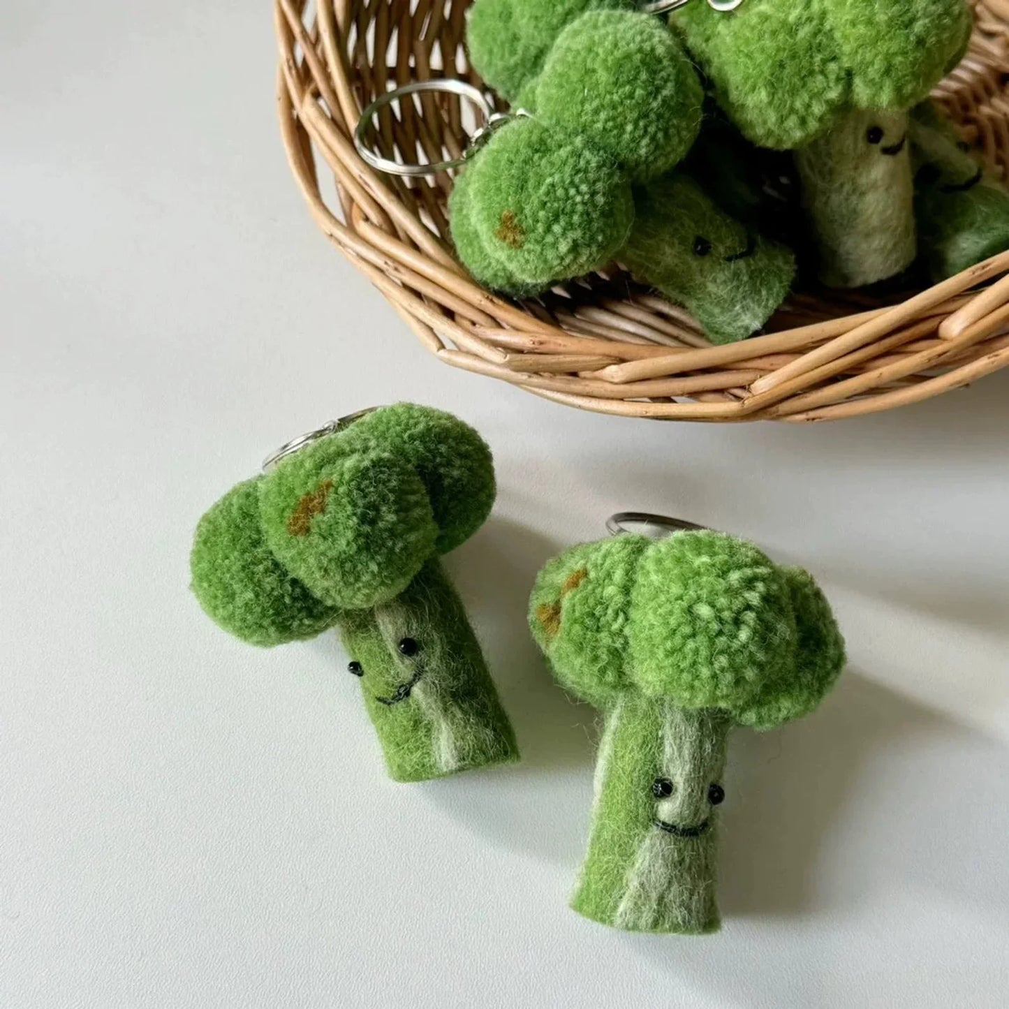 Two wool felt broccoli charms with smiling faces