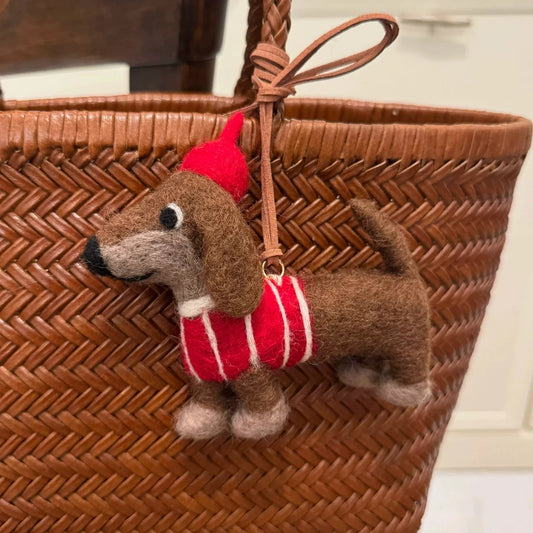 Wool felt dachshund bag charm with a red beret on a woven basket