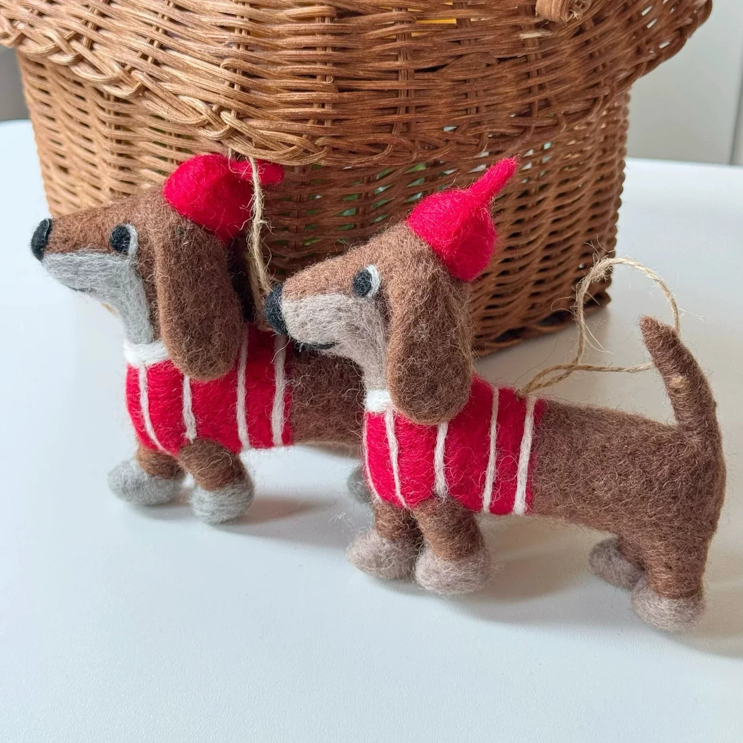 Two brown wool felt dachshund charms with red striped sweaters
