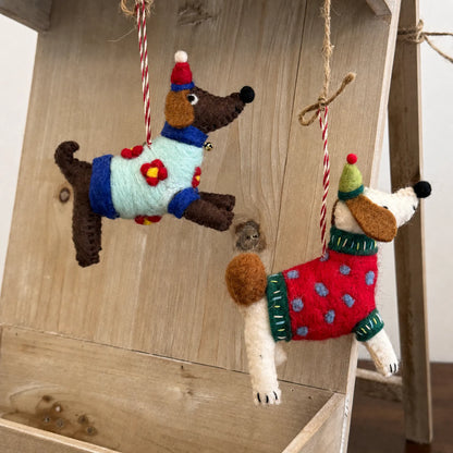 Colorful wool felt dog charms hanging in a warm lifestyle setting