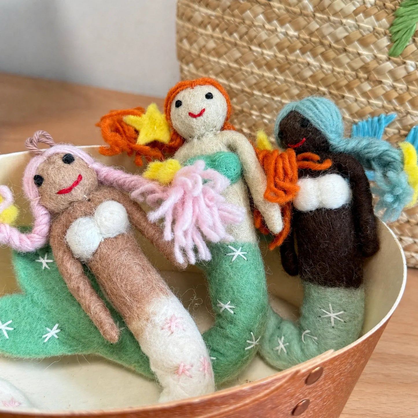 Wool felt mermaid charms grouped in a copper tray