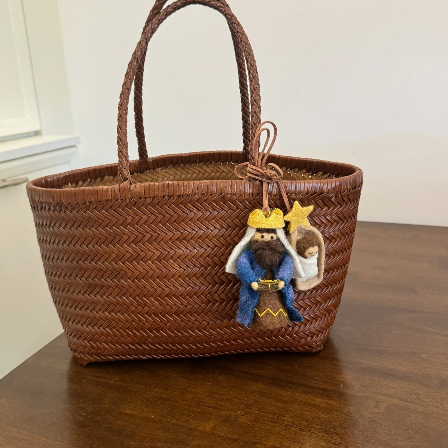 Wool felt storybook character charms styled on a woven tote bag
