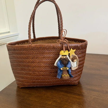 Wool felt storybook character charms styled on a woven tote bag
