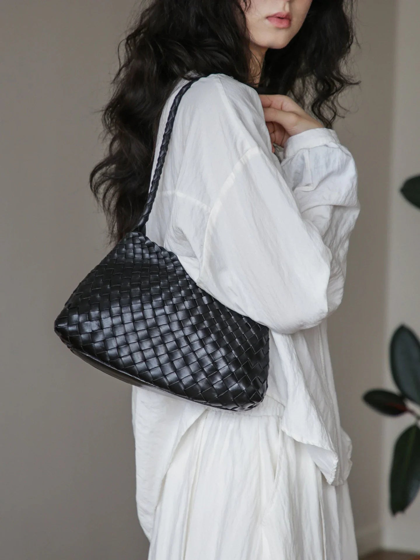Black woven leather shoulder bag in side profile