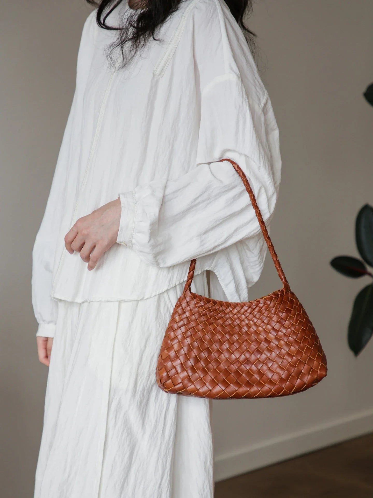 Brown woven leather shoulder bag shown in a relaxed full view