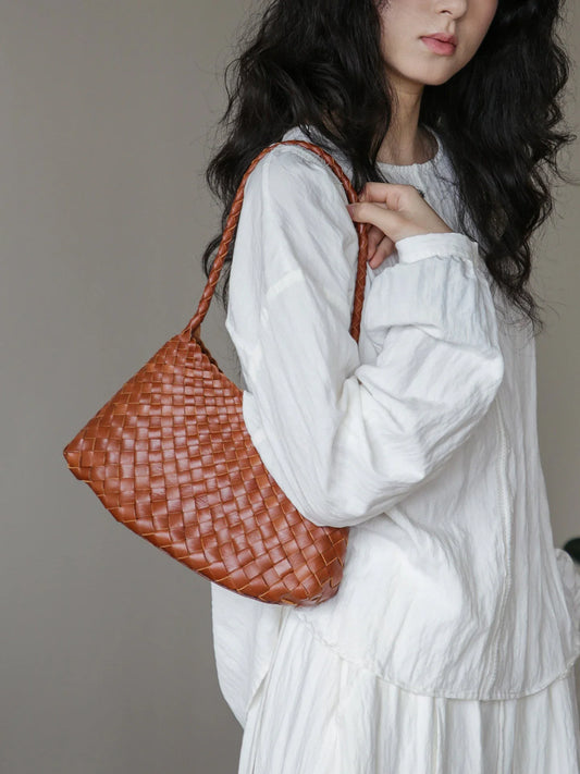 Brown vegetable-tanned woven leather shoulder bag styled under the arm